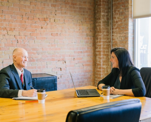 man and woman talking inside office