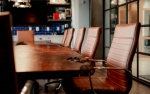 a meeting room with large table and leather chairs