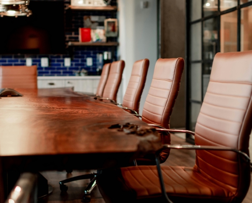 a meeting room with large table and leather chairs